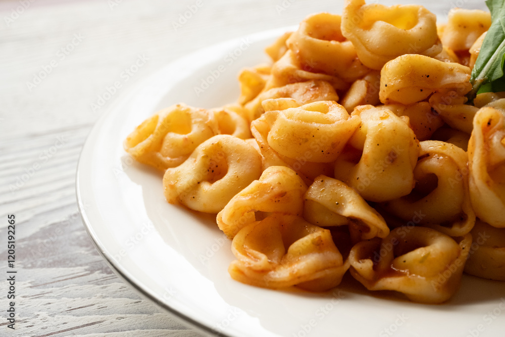 Tortellini with tomato sauce on a white plate Tortellini with tomato sauce on a white plate