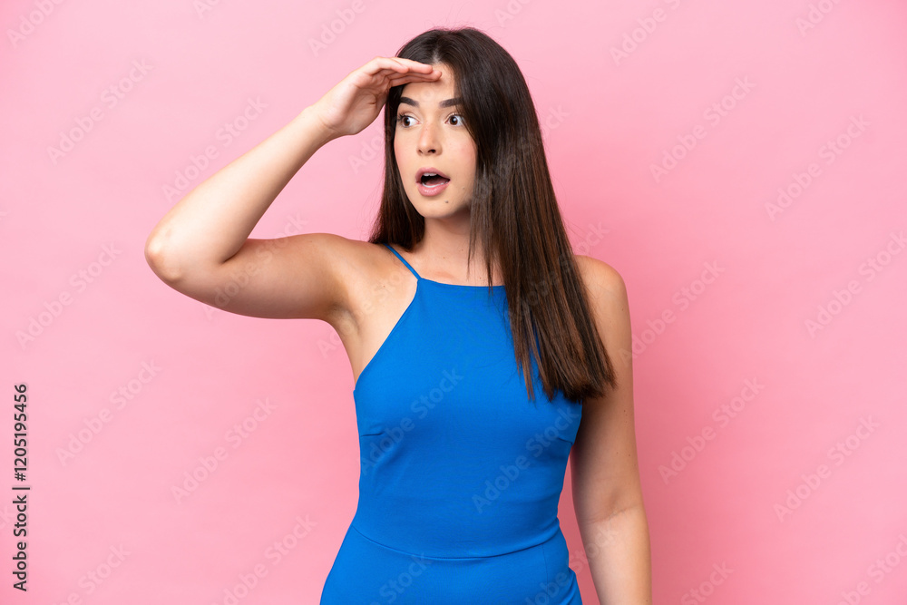 Young Brazilian woman isolated on pink background with surprise expression while looking side Young Brazilian woman isolated on pink background with surprise expression while looking side