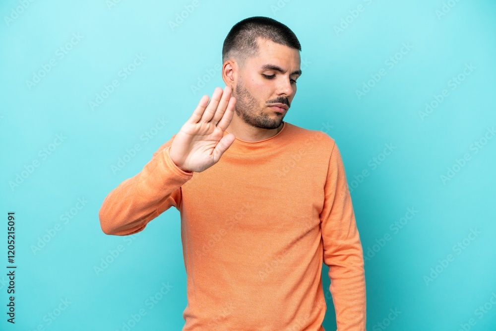 Young caucasian man isolated on blue background making stop gesture and disappointed Young caucasian man isolated on blue background making stop gesture and disappointed