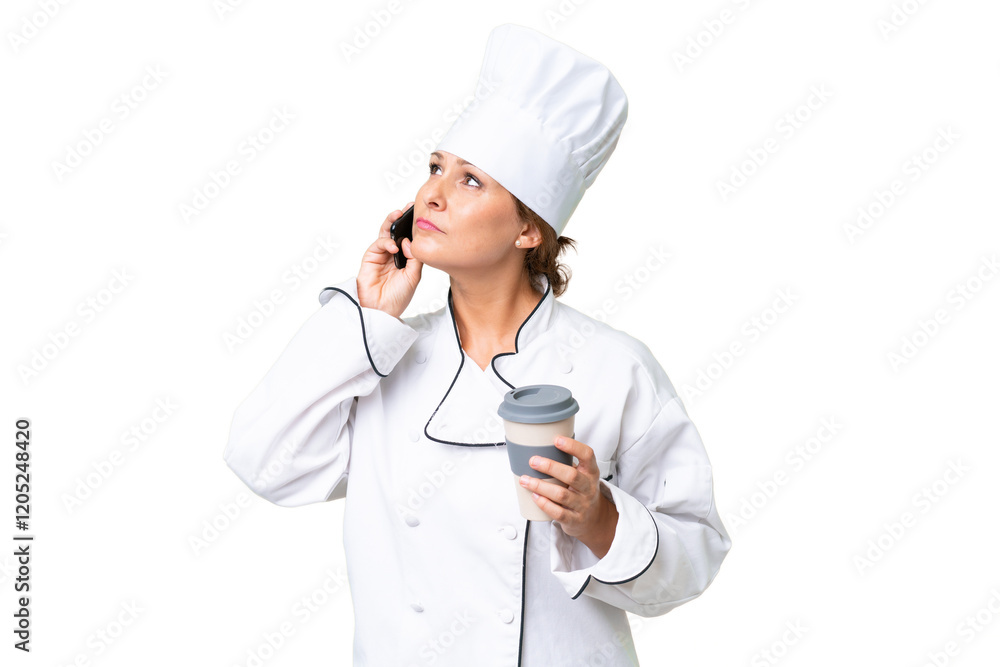 Middle-aged chef woman over isolated background holding coffee to take away and a mobile Middle-aged chef woman over isolated background holding coffee to take away and a mobile