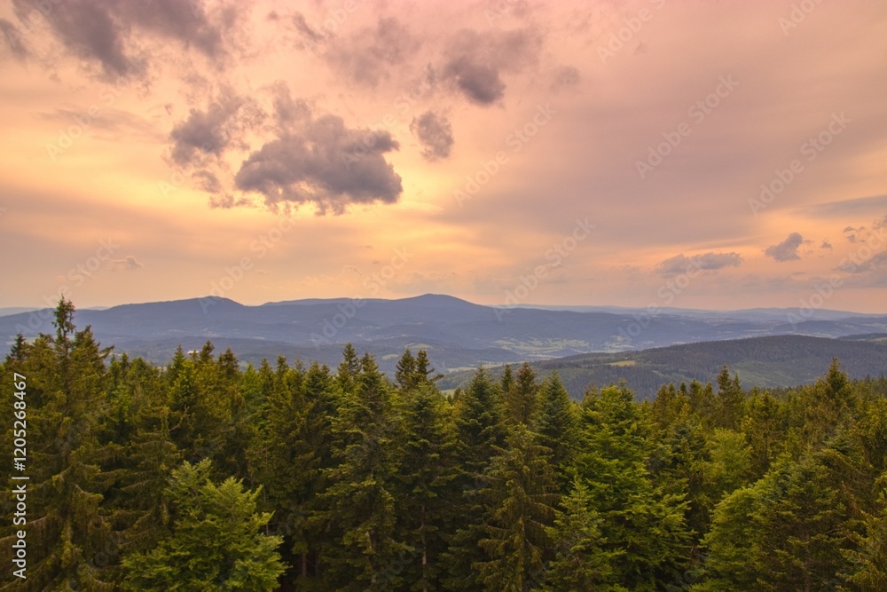 A view to the mountains Bobik and Boubin of Sumava National Park from lookout tower Libin in closing sunset
