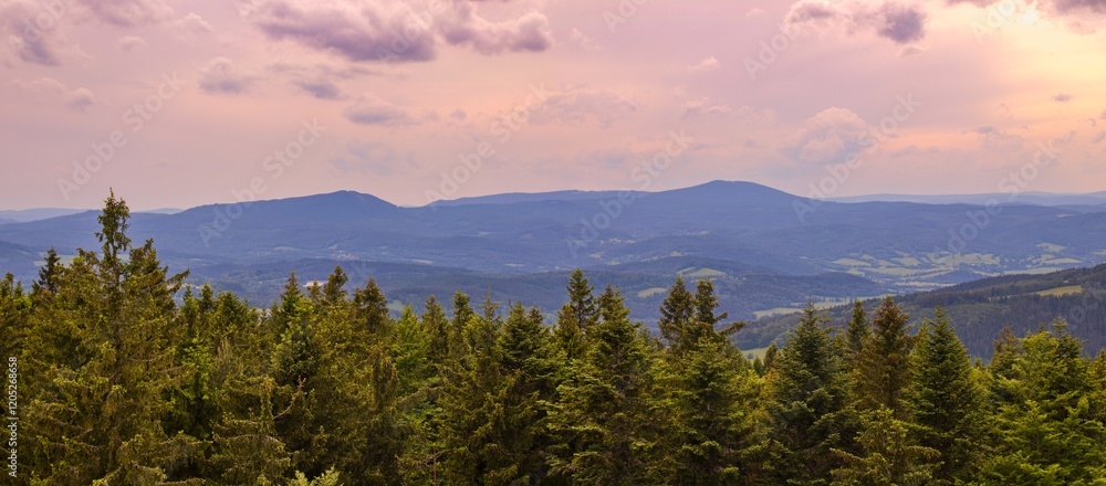 A view to the mountains Bobik and Boubin of Sumava National Park from lookout tower Libin in closing sunset