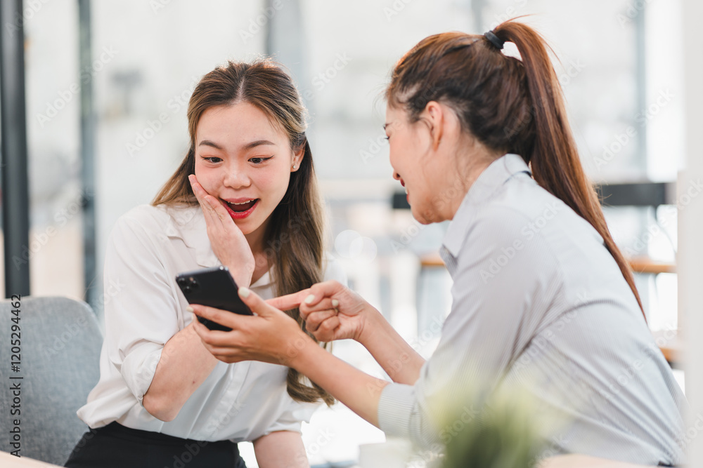 Two women sitting together in bright office space, sharing moment of surprise and excitement while looking at smartphone screen. atmosphere is cheerful and engaging. Two women sitting together in bright office space, sharing moment of surprise and excitement while looking at smartphone screen. atmosphere is cheerful and engaging.