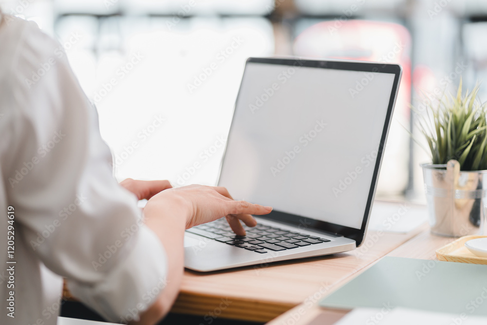Person typing on blank screen laptop at desk, creating productive and focused workspace. Person typing on blank screen laptop at desk, creating productive and focused workspace.