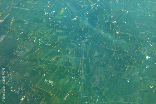 Obraz na płótnie Captivating aerial view of a rural landscape with a central straight road dividing agricultural fields into geometric shapes, offering a striking look at land use patterns and rural planning w salonie