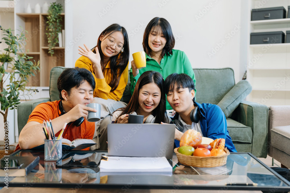 Asian college student reading a book study on laptop prepare for the exam or work on a group project at home. Asian college student reading a book study on laptop prepare for the exam or work on a group project at home.