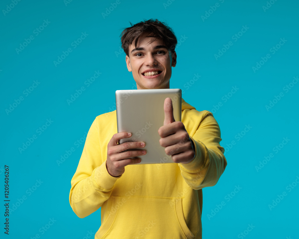 young casual man watching movie on pad makes ok sign young casual man watching movie on pad makes ok sign