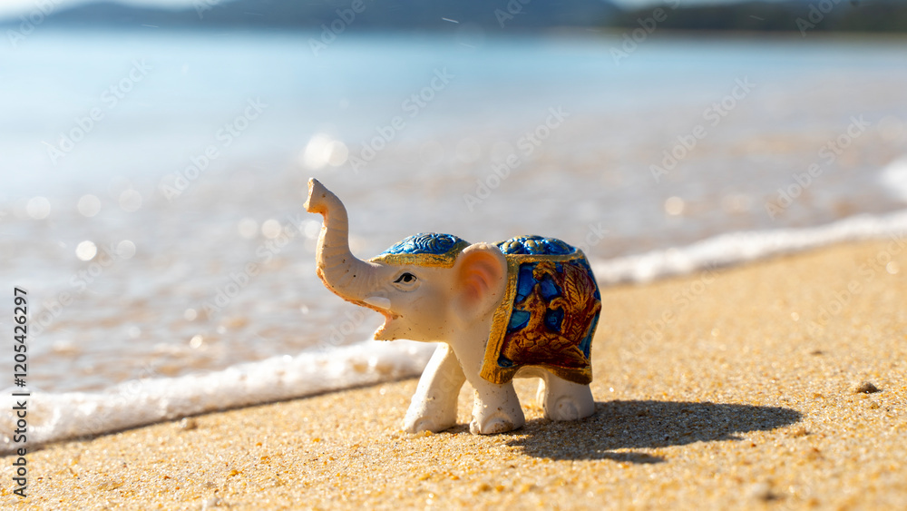 Obraz premium figurine of an elephant on the beach by the sea. travel and vacation concept