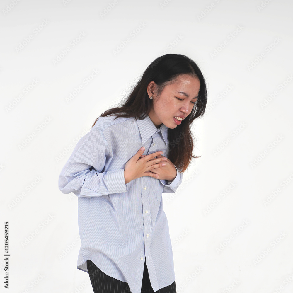 Asian women wearing light blue shirt and long hair with hands pressing on chest gesture. Heart pain themed photo isolated on white background. Asian women wearing light blue shirt and long hair with hands pressing on chest gesture. Heart pain themed photo isolated on white background.