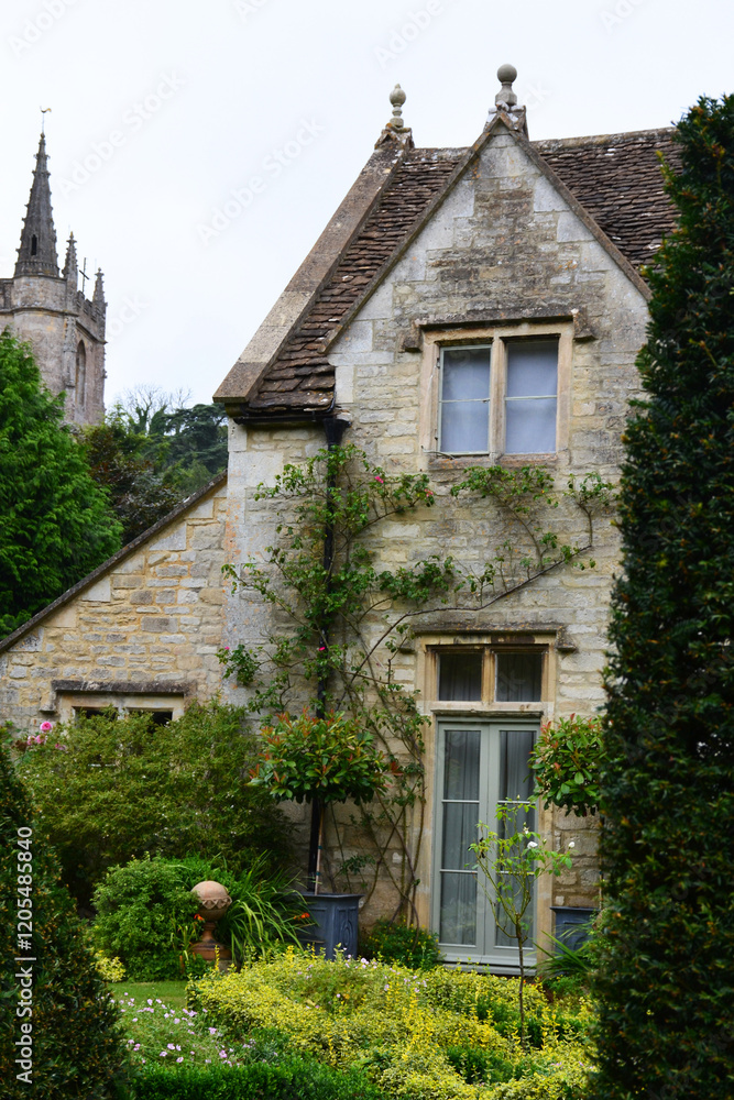 Fototapeta premium View of a stone house and church in the picturesque village of Castle Combe, Cotswolds, Wiltshire England, UK