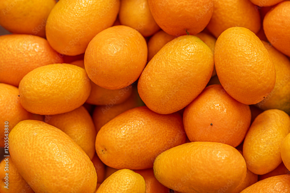 fresh ripe kumquats on a counter at the market close up fresh ripe kumquats on a counter at the market close up