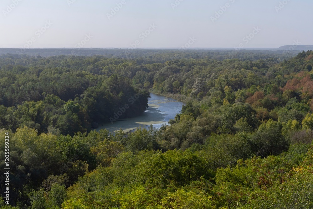 Beautiful view of the river from the top of the hill. Landscape with a river and a steep bank on an autumn morning.