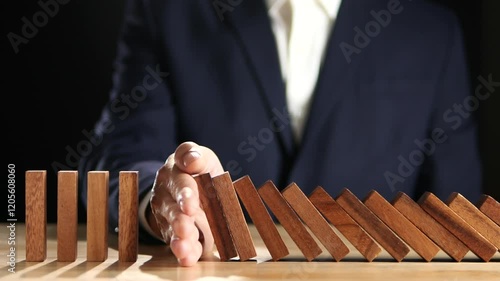 Concept of Risk Assessment, Crisis, Economic, Business Management, Inflation. Hand of businessman stopping, prevent falling block, domino effect to safe family life, property, insurance from crisis.