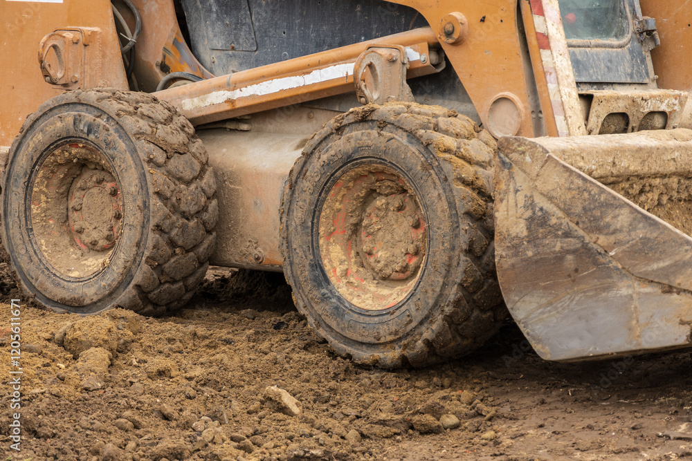 Heavy machinery including a backhoe and bulldozer is actively digging and moving dirt at a construction site on a sunny day Heavy machinery including a backhoe and bulldozer is actively digging and moving dirt at a construction site on a sunny day