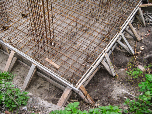 Reinforced steel bars and formwork installed for a concrete foundation slab at a construction site. photo