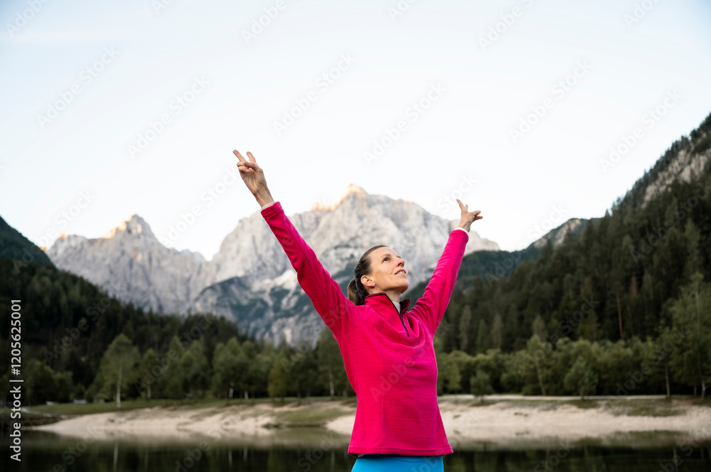 Female hiker celebrating life with arms raised high in the air Female hiker celebrating life with arms raised high in the air
