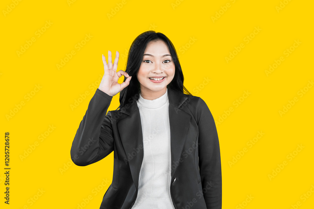 Confident Businesswoman Making OK Gesture on Yellow Background Confident Businesswoman Making OK Gesture on Yellow Background