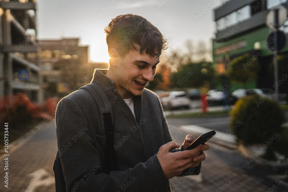 Fototapeta premium young adult man stand and use mobile phone on the street