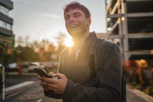 young adult man stand and use mobile phone on the street photo