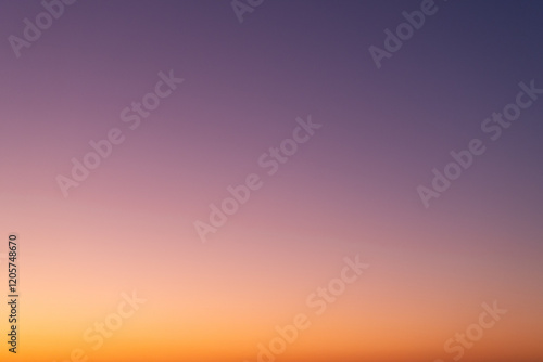 Clear sunset sky background. Vibrant gradient from orange to purple. Beautiful and natural color transient without any clouds. Real sky view.