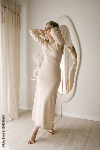Obraz na płótnie Beautiful blonde woman posing in beautiful modern stylish beige interior on photo of large mirror w salonie