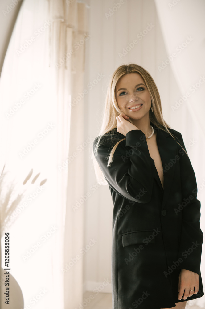 Beautiful blonde woman posing in beautiful modern stylish beige interior on photo of large mirror