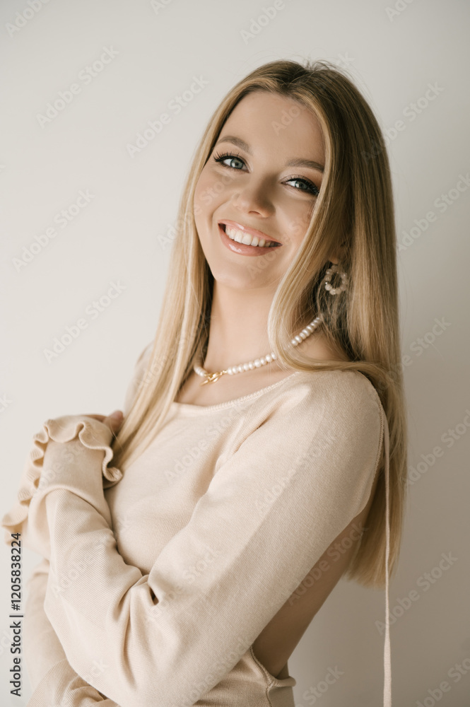 Portrait of smiling blonde woman with beautiful white smile in modern stylish beige interior