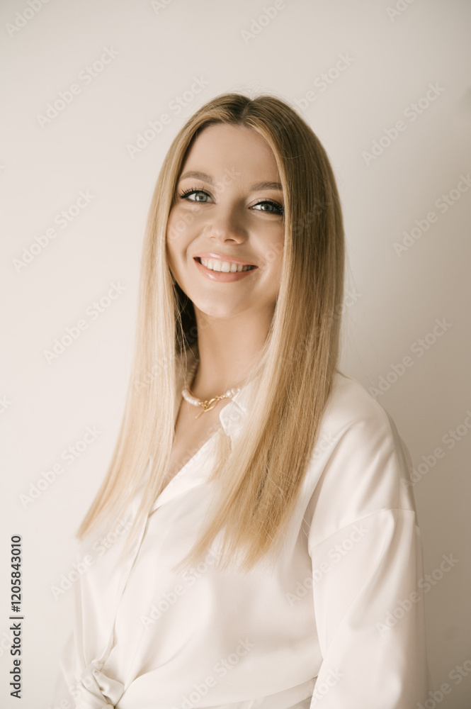 Portrait of smiling blonde woman with beautiful white smile in modern stylish beige interior