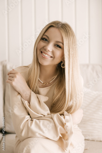 Obraz na płótnie Portrait of smiling blonde woman with beautiful white smile in modern stylish beige interior w salonie