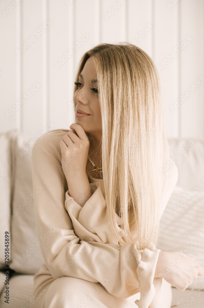 Beautiful blonde woman posing in a beautiful modern stylish beige interior Beautiful blonde woman posing in a beautiful modern stylish beige interior
