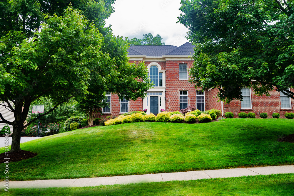 Obraz premium large country house in the English style with a large mowed lawn in front of the entrance.