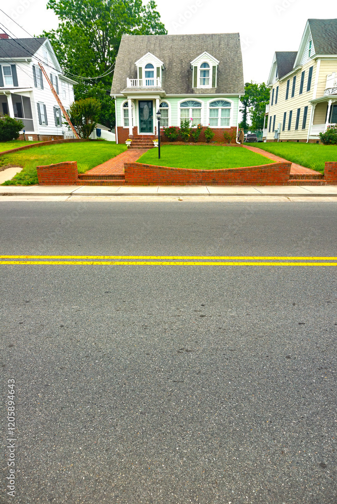 Small cute house by the road. View of the porch with lawn and walkway. Space for text. Small cute house by the road. View of the porch with lawn and walkway. Space for text.