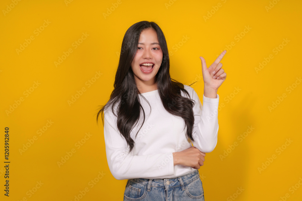 Young brunette woman pointing and showing something on yellow background Young brunette woman pointing and showing something on yellow background