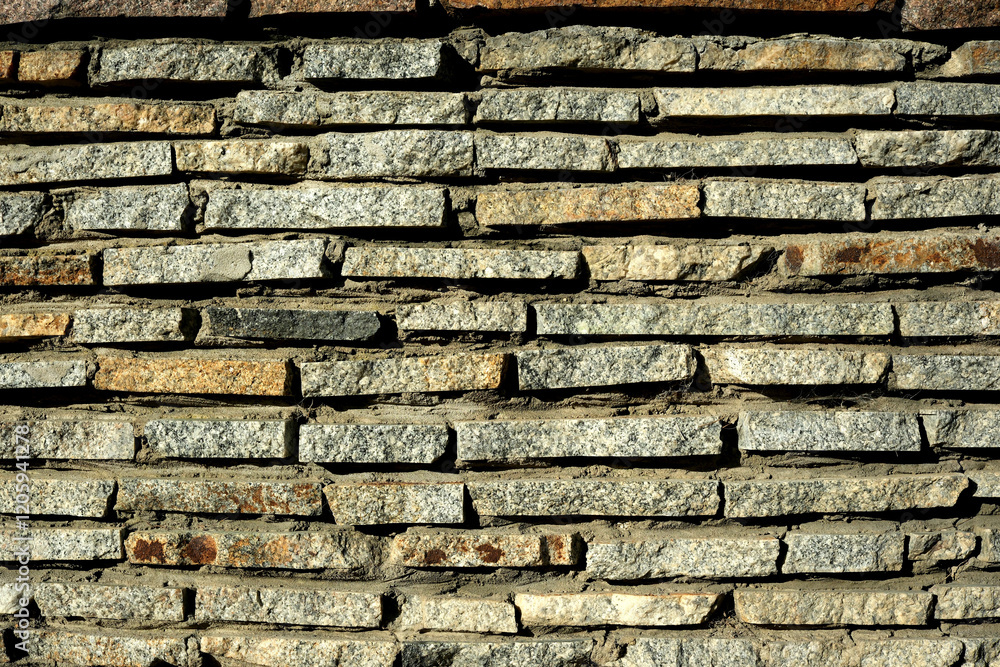 Rustic stone wall highlights earthy tones and texture Rustic stone wall highlights earthy tones and texture