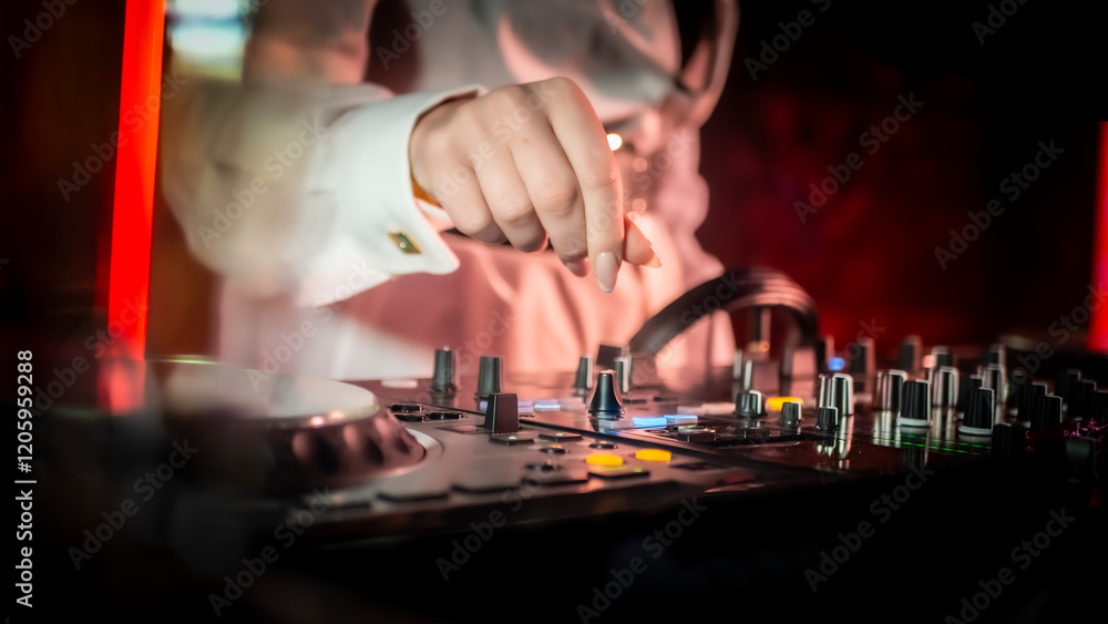 Naklejka premium Close up DJ plays live set and mixing music on turntable console in the night club. Disc Jokey Hands on a sound mixer station at club party. DJ mixer controller panel for playing music and partying.