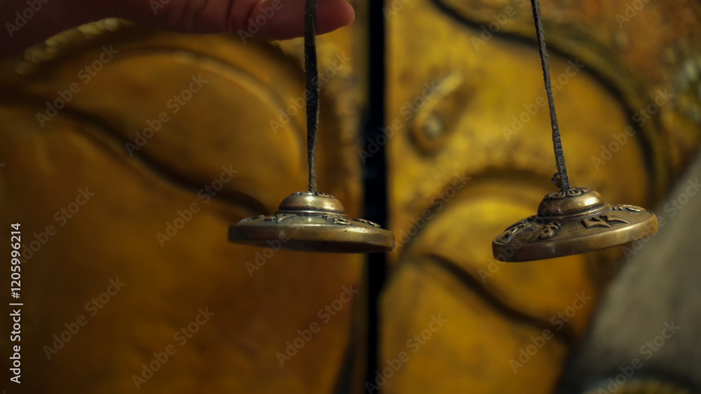 Hand holding tibetan cymbals for meditation and relaxation
