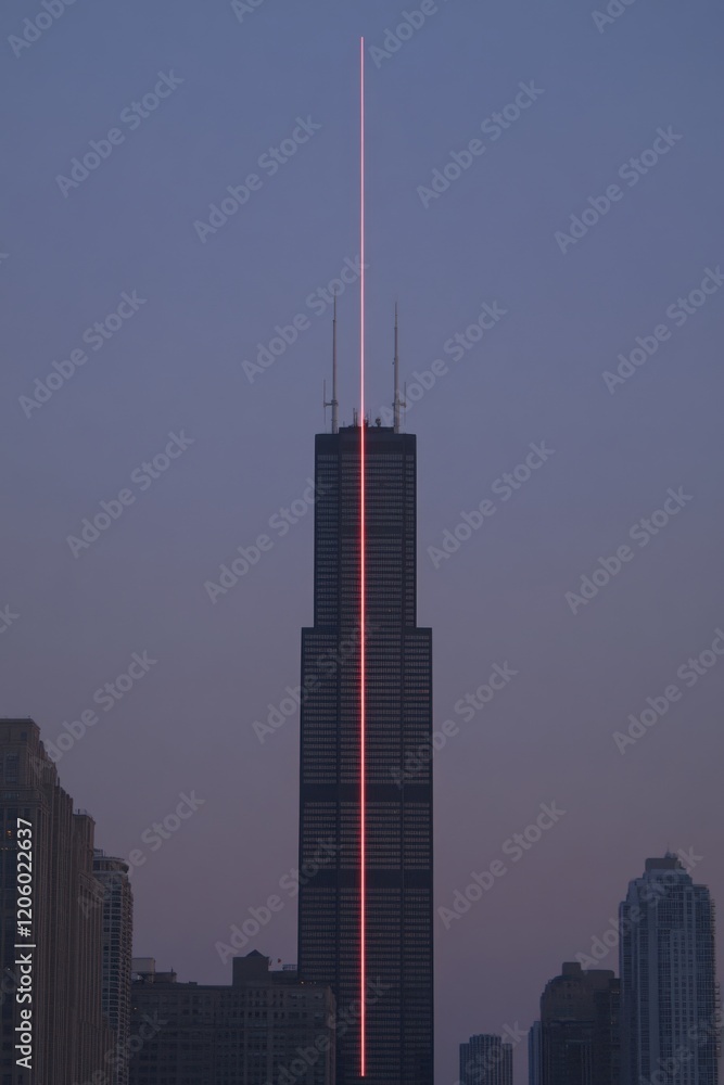 Obraz premium Cityscape Silhouette with Laser Beam Striking Tall Building at Dusk