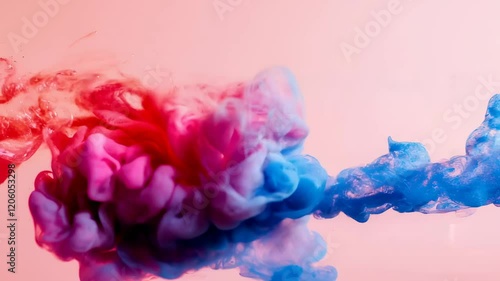 Vibrant red and blue ink clouds swirling and blending in water on a soft pink background
