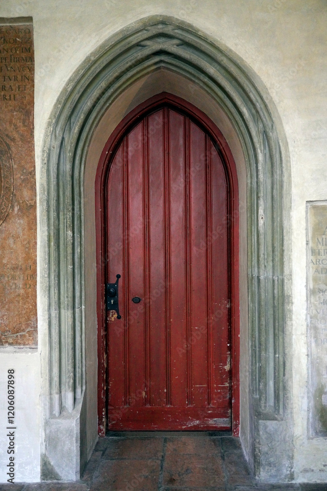 Arched red door set in a medieval church in southern Germany Arched red door set in a medieval church in southern Germany