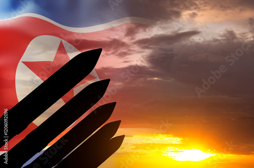 Silhouette of missiles against the sunset with North Korea flag photo