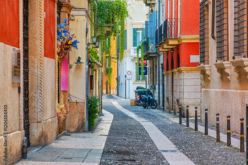 Obraz premium Medieval narrow street with colorful building facades and cobblestone in Verona old town, Veneto, Italy at sunrise. Italian street with nobody. Travel destination in Europe