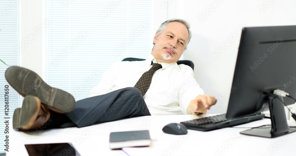 Relaxed senior businessman taking a break at desk Relaxed senior businessman taking a break at desk