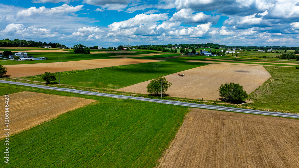 Vast agricultural fields dominate the landscape, showcasing a mix of green crops and brown earth. Vast agricultural fields dominate the landscape, showcasing a mix of green crops and brown earth.