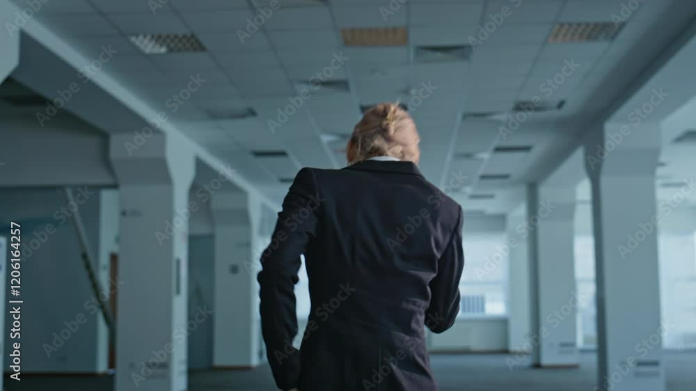 Irritated boss calling smartphone feeling stress at grey office hall back view Irritated boss calling smartphone feeling stress at grey office hall back view