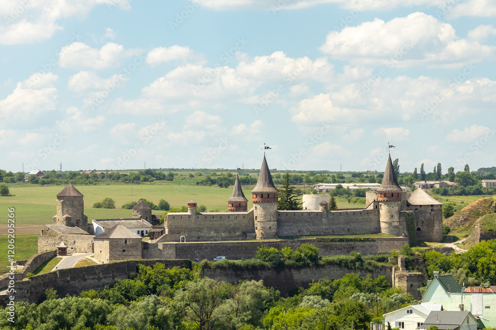 Fototapeta premium Historic medieval castle with towers under a blue sky and green surroundings