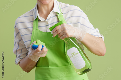 Wallpaper Mural Modern woman in green apron and rubber gloves isolated on green Torontodigital.ca