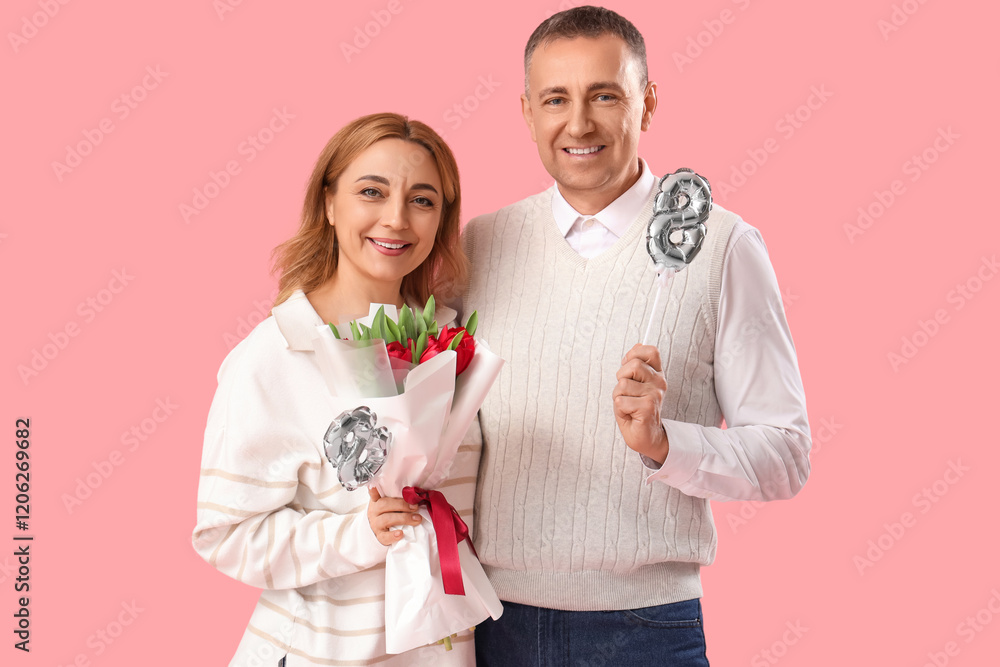 Middle-aged couple with bouquet of flowers and balloon in shape of figure 8 on pink background. International Women's Day Middle-aged couple with bouquet of flowers and balloon in shape of figure 8 on pink background. International Women's Day