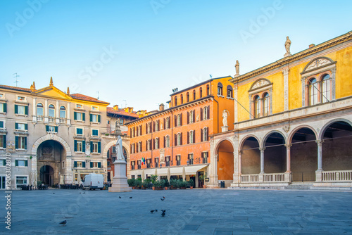 Verona old town square Piazza dei Signori with Dante Alighieri statue and Palazzo dell Podesta with nobody, Veneto, Italy. Italian square with colorful buildings. Tourist and travel destination photo