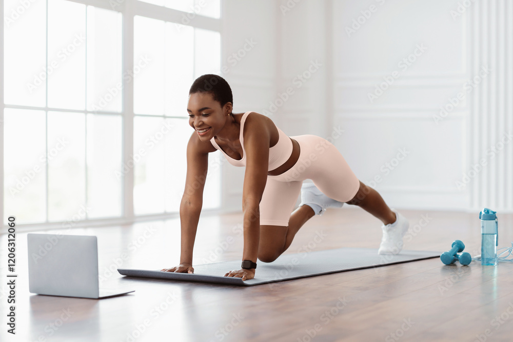 Fototapeta premium Smiling Sporty Sporty Woman Training At Spacious Room In Front Of Laptop, Beautiful Lady Doing Cross Body Mountain Climbers Exercise Looking At Screen Having Online Video Call With Trainer Instructor