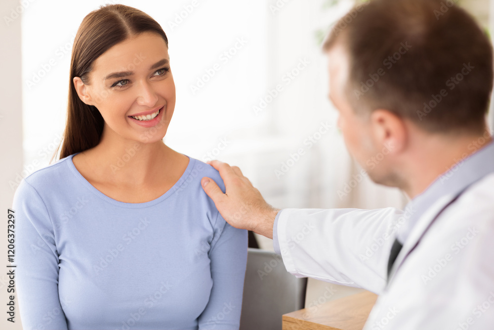 Encouragement Concept. Smiling woman visiting doctor, general practitioner telling good news to his patient, reassuring, holding hand on her shoulder. Health Care and Medicine Concept Encouragement Concept. Smiling woman visiting doctor, general practitioner telling good news to his patient, reassuring, holding hand on her shoulder. Health Care and Medicine Concept